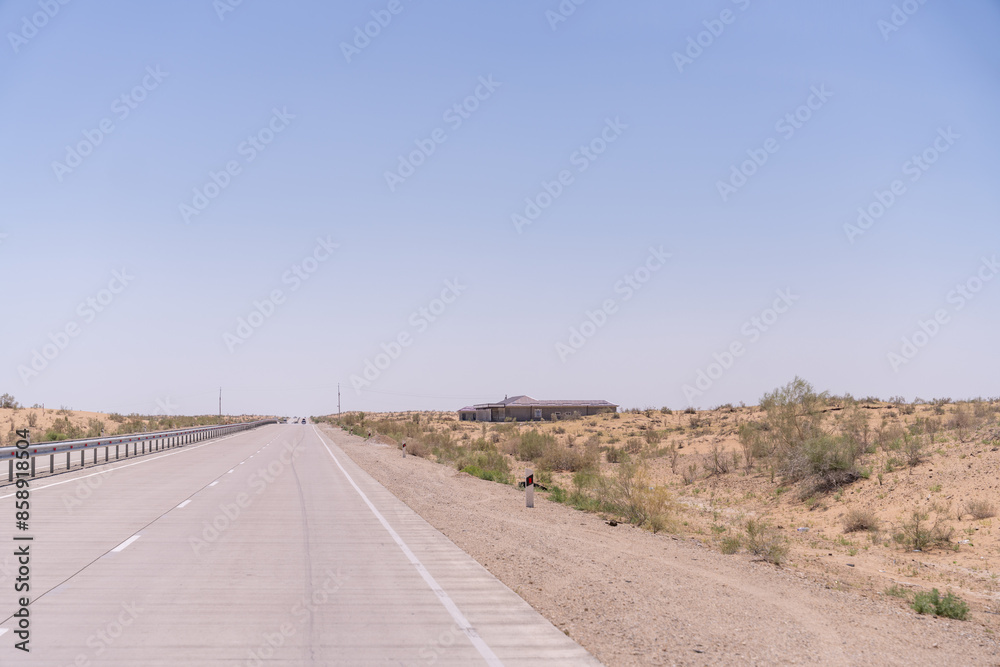 A road with a building in the distance. The road is empty and the sky is clear A road with a building in the distance. The road is empty and the sky is clear