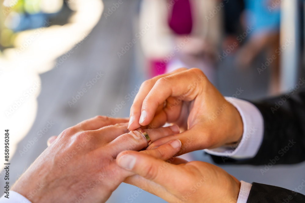 A man is getting his ring put on by another man A man is getting his ring put on by another man