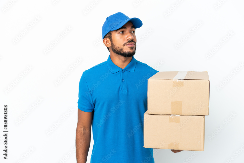 Delivery Ecuadorian man isolated on white background looking to the side Delivery Ecuadorian man isolated on white background looking to the side