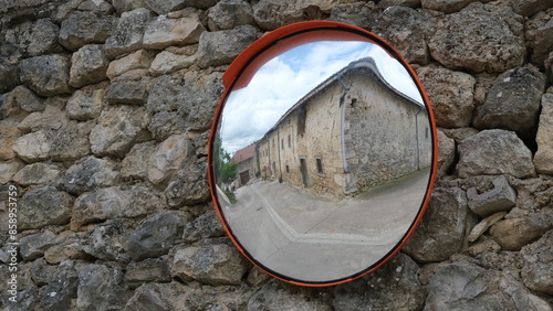 Mirror on stone wall. Reflection in rural area.