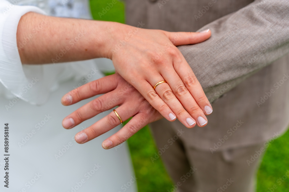 A couple is holding hands and wearing wedding rings A couple is holding hands and wearing wedding rings