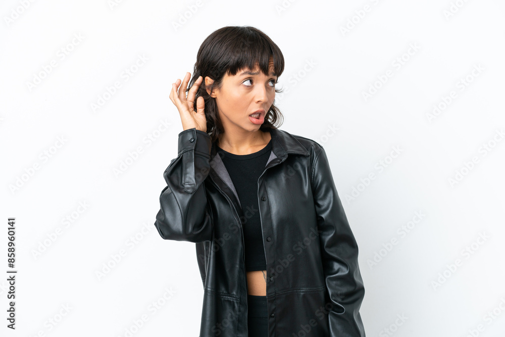 Young mixed race woman isolated on white background listening to something by putting hand on the ear Young mixed race woman isolated on white background listening to something by putting hand on the ear