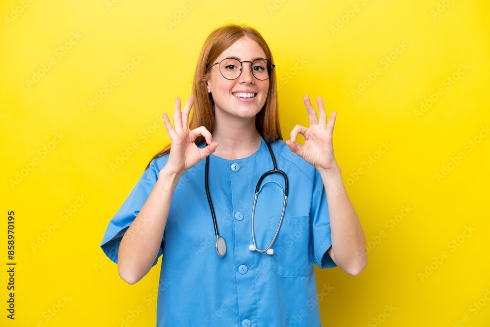 Young redhead nurse woman isolated on yellow background showing an ok sign with fingers Young redhead nurse woman isolated on yellow background showing an ok sign with fingers