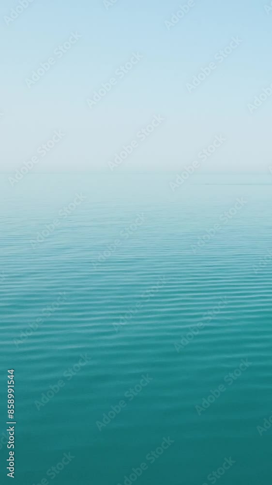 Vertical aerial view over calm azure sea water surface. Sun glare. Abstract nautical summer ocean nature. Holiday, vacation and travel concept. Nobody. Weather and climate change Vertical aerial view over calm azure sea water surface. Sun glare. Abstract nautical summer ocean nature. Holiday, vacation and travel concept. Nobody. Weather and climate change