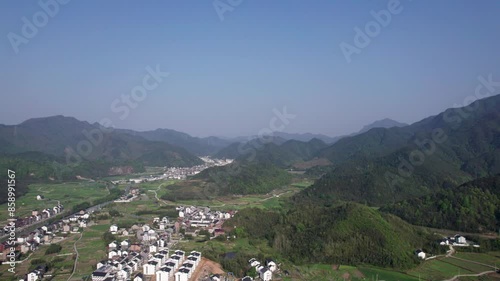 Aerial view of Chinese traditional village in Fuyang, Hangzhou, Zhejiang, China. Drone fly view of traditional villages in sunny spring day, white walls in agriculture field, 4k real time footage. photo