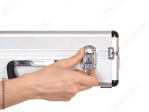 A woman's hand opens the lock on a small aluminum suitcase isolated on a white background