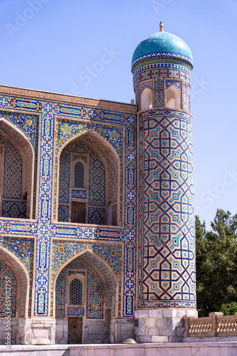 A tall building with blue and white tiles and a blue dome. The building has a lot of arches and is very ornate