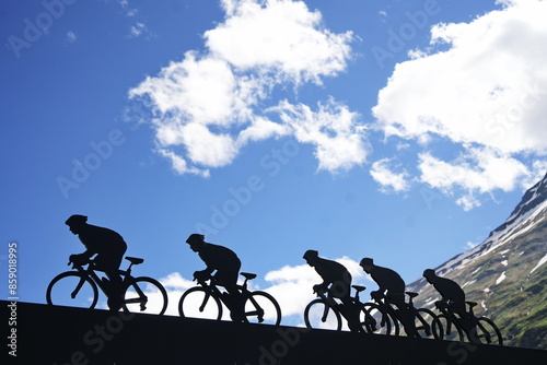 Lanslebourg-Mont-Cenis , France - June 20 2024: A group of cyclists tackle the steep Alpine climb in the back light.