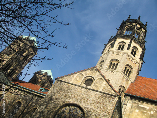 The detailed church of St Ludgeri at a skew angle, in the German city of Münster, against a blue sky. photo