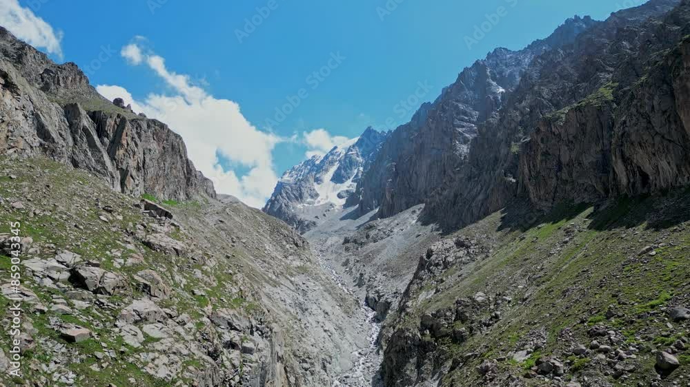 Mountain gorge at altitude of more 2600 meters. Rocky Mountains slopes, snow-capped peaks. Natural landscape, Ala-Archa national park, trekking area Kyrgyzstan. Aerial drone footage. Summer Kirgiziya 