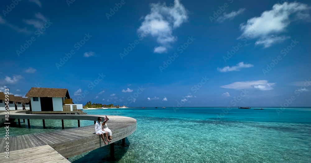 Fototapeta premium Happy moment with Couple in white dress near swimming pool at Maldives