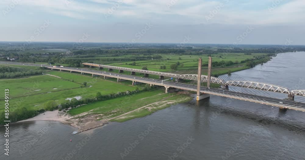 Infrastructure of the Netherlands. Highway bridge over the river Waal and Train crossing by rail road. Aerial view. Infrastructure of the Netherlands. Highway bridge over the river Waal and Train crossing by rail road. Aerial view.