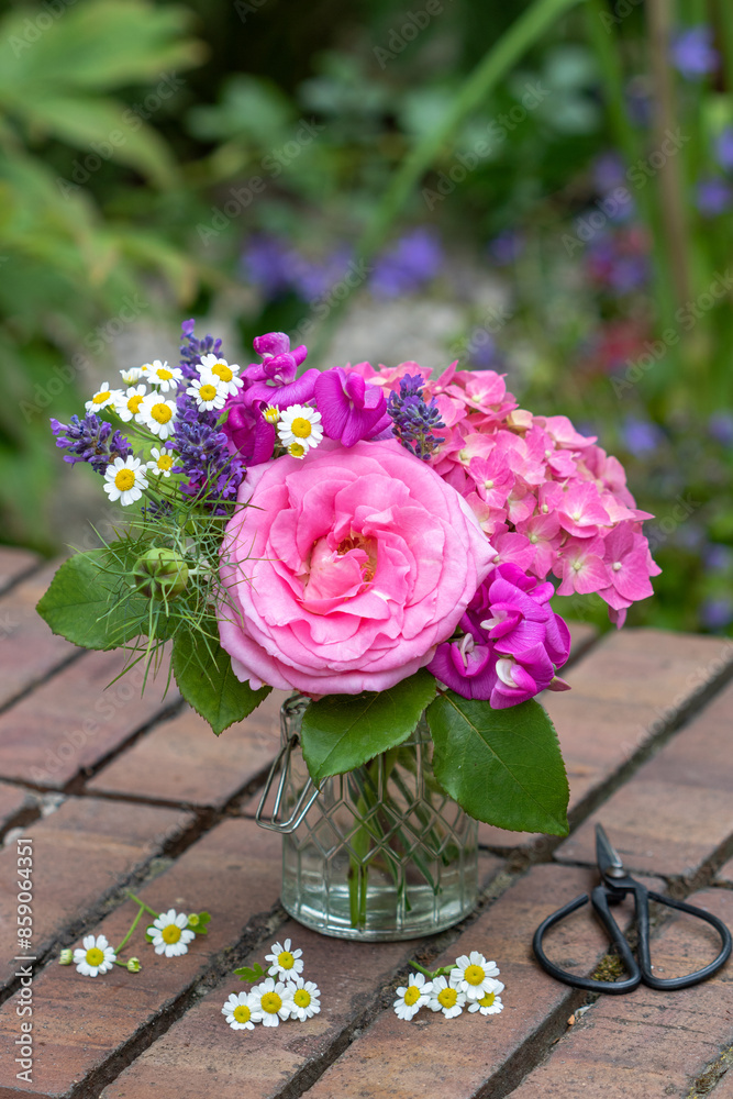 Blumenstrauß mit pink Rose, Hortensienblüten, Wicken, Lavendel und Mutterkraut in Glasvase im Garten Blumenstrauß mit pink Rose, Hortensienblüten, Wicken, Lavendel und Mutterkraut in Glasvase im Garten