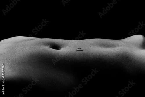 Beautiful female body in honey on dark background, studio photo