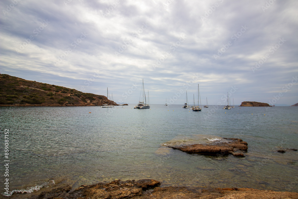 Serene coastal landscape a stunning view of rocky cliffs meeting the calm blue sea, with sailboats gliding peacefully across water Under a softly clouded sky, Serene coastal landscape a stunning view of rocky cliffs meeting the calm blue sea, with sailboats gliding peacefully across water Under a softly clouded sky,