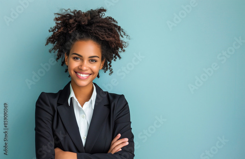 Smiling black businesswoman in dark suit on teal studio background with copy space