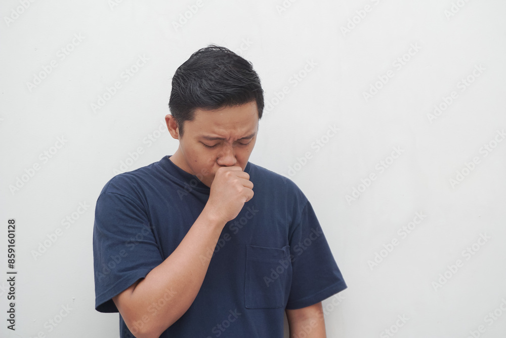 Young Asian man coughing isolated on white. Man suffering from cold symptoms. Healthy concept.
Young Asian man coughing isolated on white. Man suffering from cold symptoms. Healthy concept.