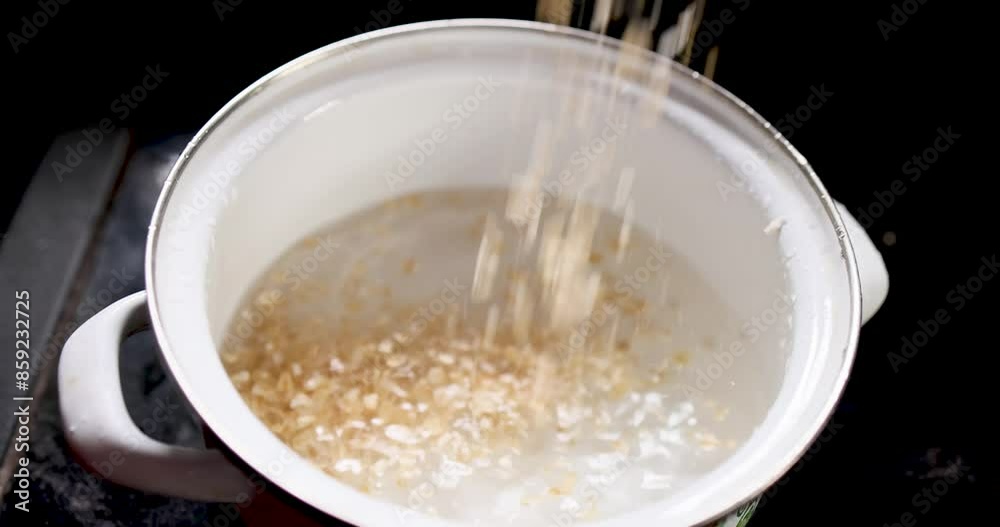 Water is poured into a bowl of oatmeal - detailed closeup Water is poured into a bowl of oatmeal - detailed closeup