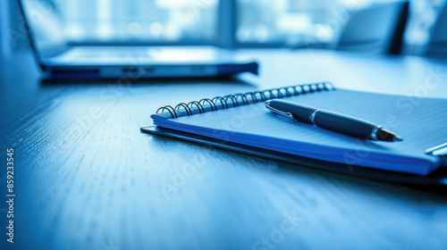 Notepad and pen on a table in blue tones, set up before a meeting. Business concept with ample copy space for notes or text.