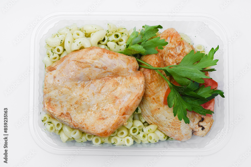 Fried chicken fillet with a side dish of pasta. Delicious meat breakfast in a container. Fried chicken fillet with a side dish of pasta. Delicious meat breakfast in a container.