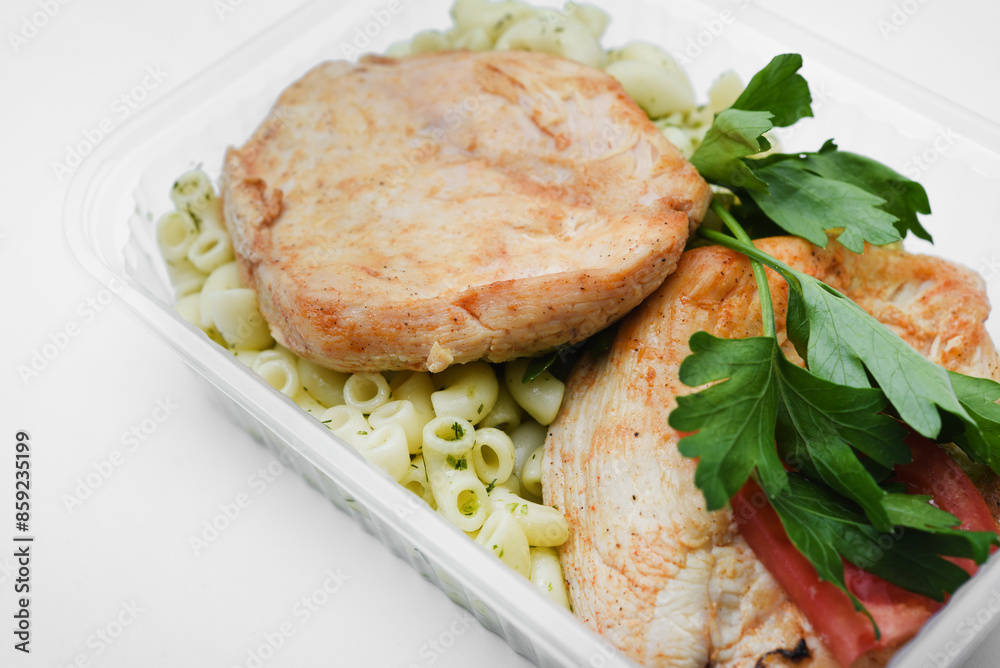 Fried chicken fillet with a side dish of pasta. Delicious meat breakfast in a container. Fried chicken fillet with a side dish of pasta. Delicious meat breakfast in a container.
