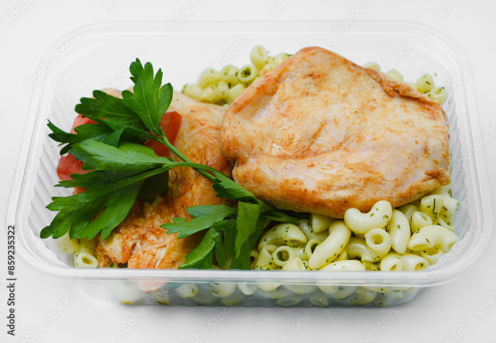 Fried chicken fillet with a side dish of pasta. Delicious meat breakfast in a container. Fried chicken fillet with a side dish of pasta. Delicious meat breakfast in a container.