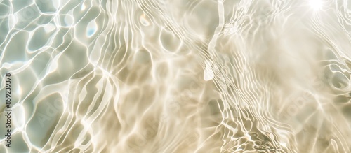 Abstract summer banner background. Clear water surface with sand underneath. Texture beach background with ripples and splashes. Water waves in sunlight, top view. Summer and vacation concept