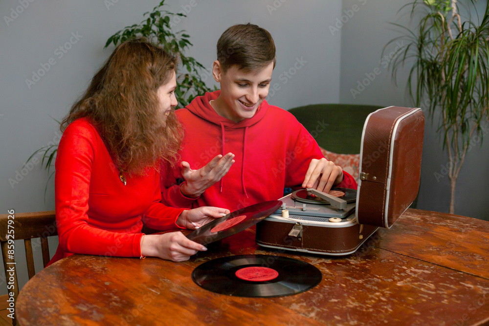 Man and Woman Sitting at Table With Record Player