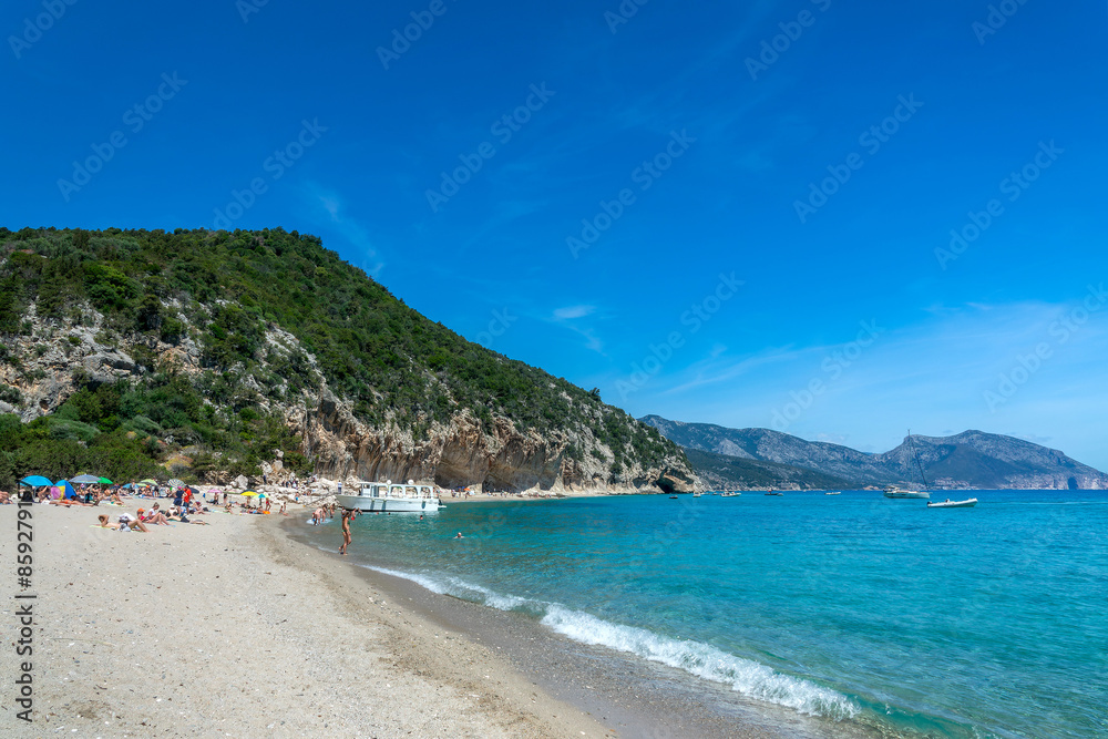 People and boats at Cala Luna beach and clear transparent blue water in the Gulf of Orosei, Sardinia island, Italy People and boats at Cala Luna beach and clear transparent blue water in the Gulf of Orosei, Sardinia island, Italy