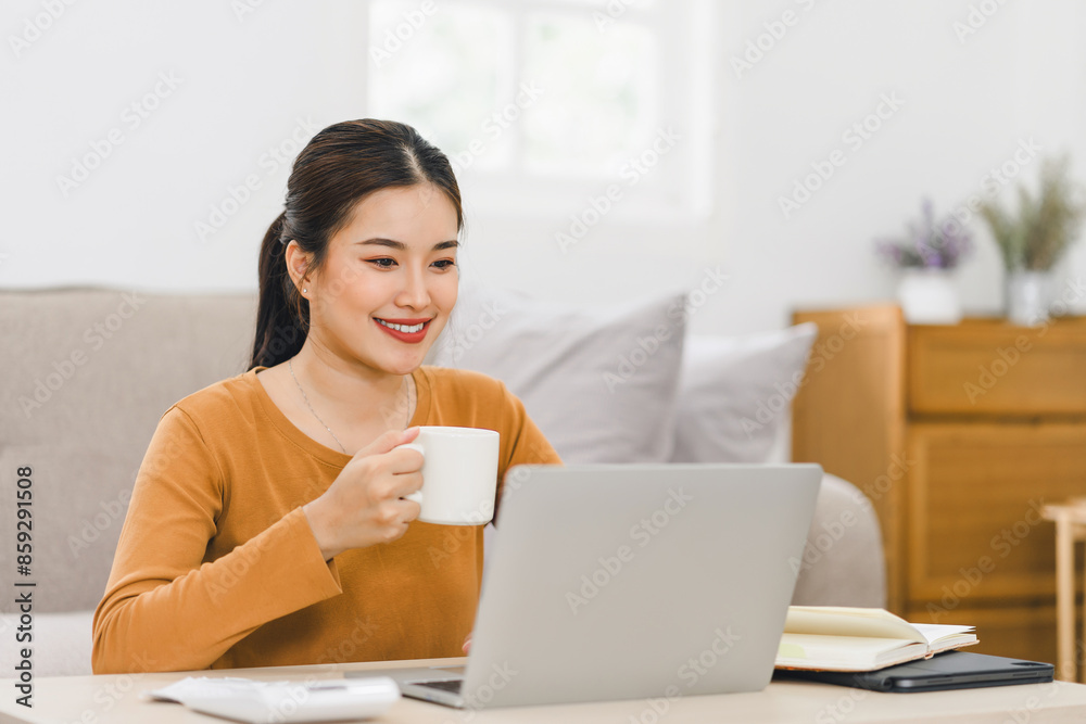 Smiling Asian Businesswoman Working on Laptop with Coffee at Home. Smiling Asian Businesswoman Working on Laptop with Coffee at Home.