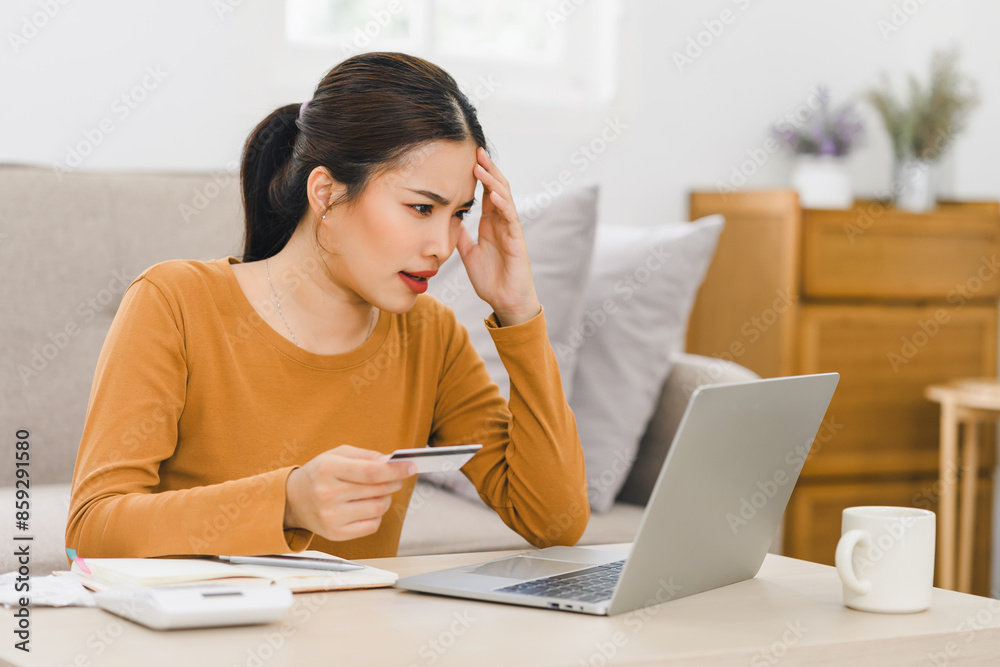 Worried woman looking at credit card statement online, managing finances and dealing with financial stress at home. Worried woman looking at credit card statement online, managing finances and dealing with financial stress at home.