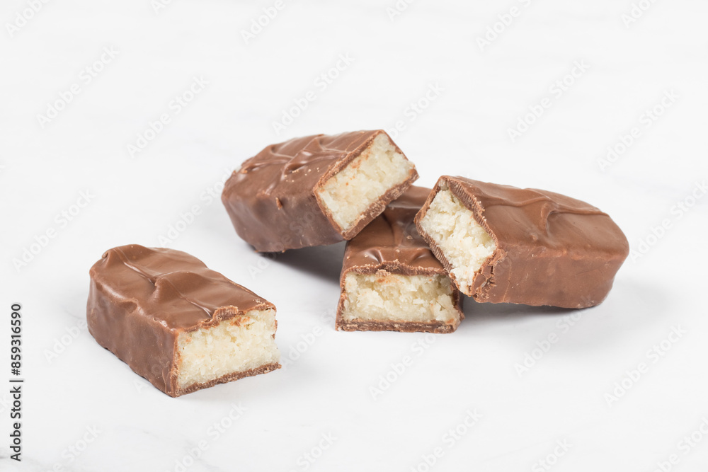 Candy bar with coconut pulp, in milk chocolate. White background. Close-up. Candy bar with coconut pulp, in milk chocolate. White background. Close-up.
