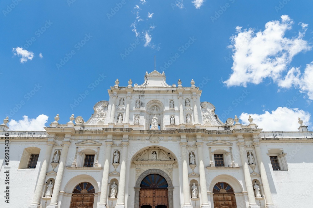 Fototapeta premium amazing and large white church facade showing sculptures of saints arches columns and doors during a bright sunny day