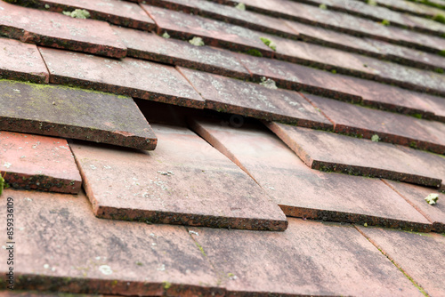 Konstfotografi Missing and slipped plain clay roof tiles on a house roof, UK