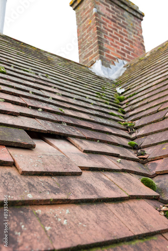Konstfotografi Missing and slipped plain clay roof tiles on a house roof, UK