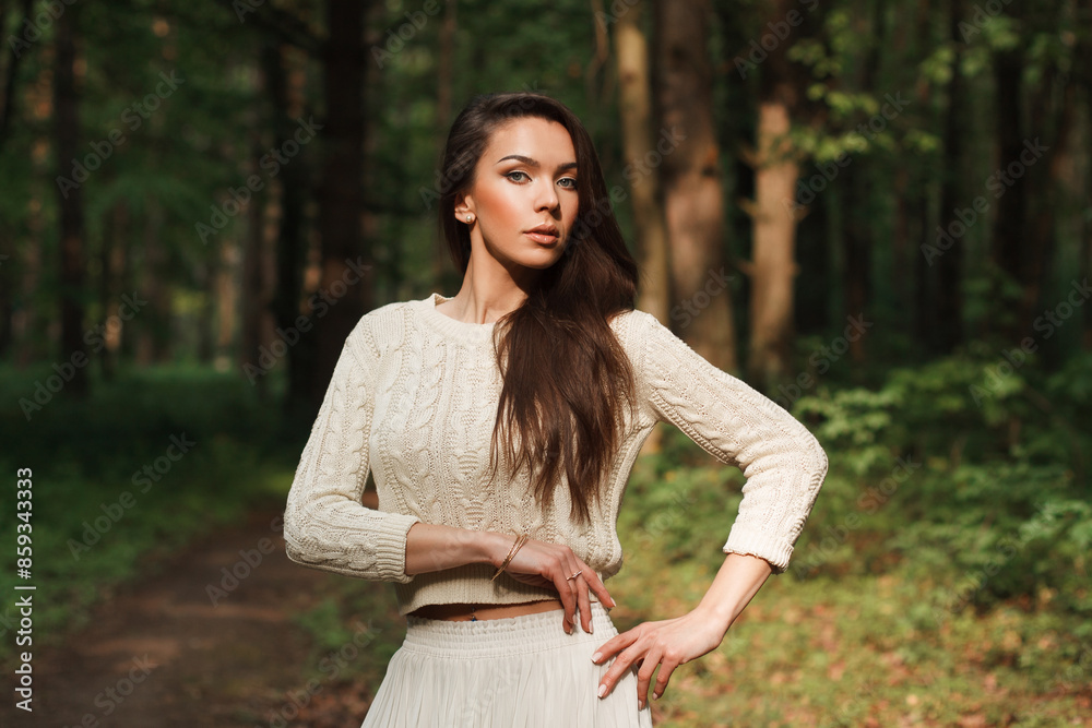 Obraz premium Beautiful natural fresh young woman in a fashion knitted sweater on a green natural background in the forest