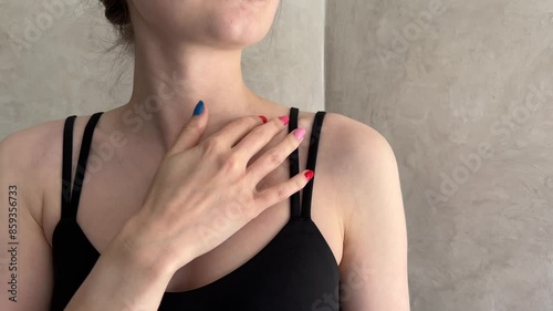 Close up of a woman with colorful manicure gently touching her shoulder in a modern interior. Perfect for beauty, fashion, and wellness themes photo