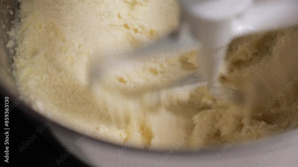 cooking in the kitchen. dessert making. cookie dough. close-up of butter and sugar in a steel mixer bowl. The ingredients are whipped with a paddle attachment at high speed. buttering cooking in the kitchen. dessert making. cookie dough. close-up of butter and sugar in a steel mixer bowl. The ingredients are whipped with a paddle attachment at high speed. buttering