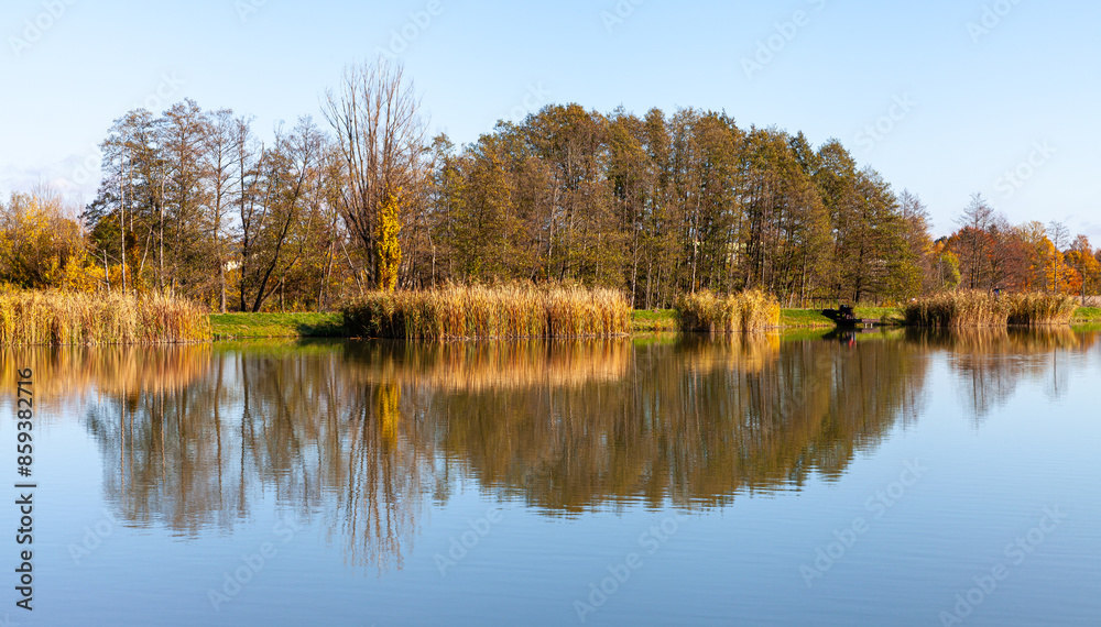 Fototapeta premium Landscape in the countryside by the lake on a sunny October day. A quiet place to relax by the water.