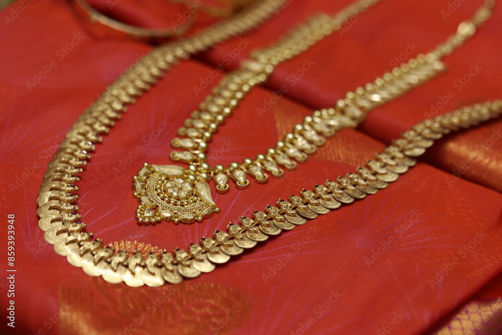 various gold chains and bangles placed on a silk saree various gold chains and bangles placed on a silk saree
