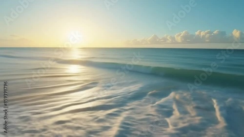 video of waves gently crashing onto a pristine sandy beach at sunrise