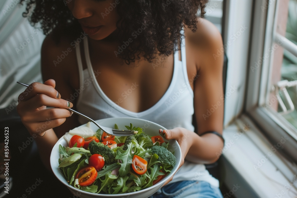 A woman is holding a salad bowl with a variety of vegetables including tomatoes. A woman is holding a salad bowl with a variety of vegetables including tomatoes.
