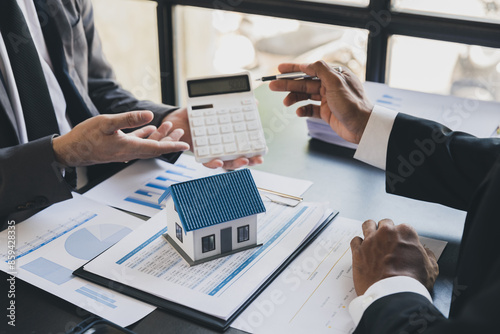 Wallpaper Mural House model with agent and customer discussing calculate for price contract to buy, get insurance or loan real estate or property. Torontodigital.ca