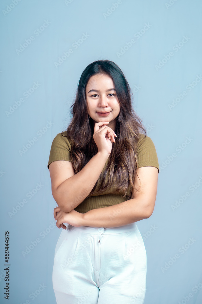 Young beautiful woman smiling joyfully and looking happy, feeling carefree and positive isolated by blue background Young beautiful woman smiling joyfully and looking happy, feeling carefree and positive isolated by blue background