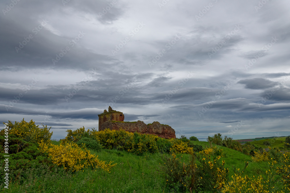 The 15th Century ruins of the Red Castle at Lunan Bay on the North East Cost of Scotland, with Flowring Gorse and storm Clouds above. The 15th Century ruins of the Red Castle at Lunan Bay on the North East Cost of Scotland, with Flowring Gorse and storm Clouds above.
