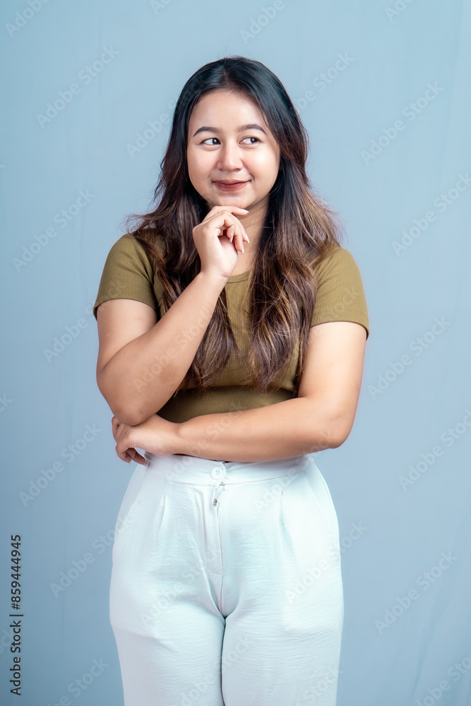 Young beautiful woman smiling joyfully and looking happy, feeling carefree and positive isolated by blue background Young beautiful woman smiling joyfully and looking happy, feeling carefree and positive isolated by blue background