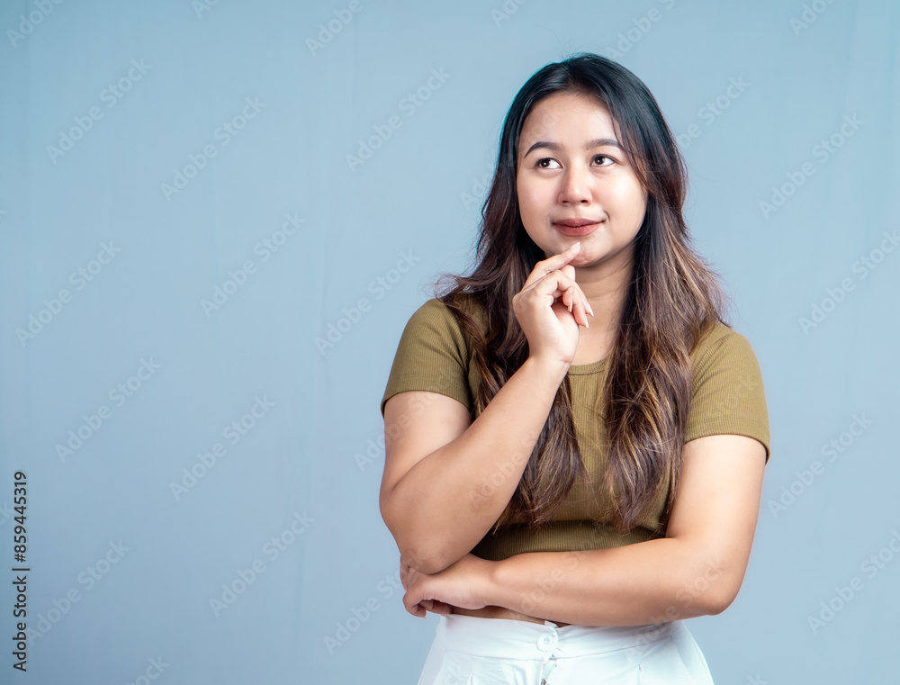 Young beautiful woman smiling joyfully and looking happy, feeling carefree and positive isolated by blue background Young beautiful woman smiling joyfully and looking happy, feeling carefree and positive isolated by blue background