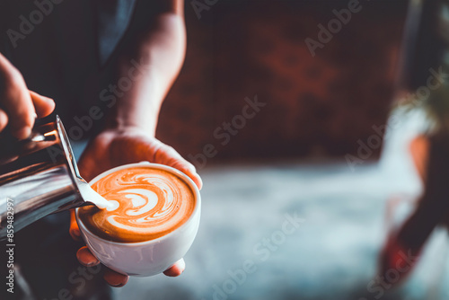 vintage tone of barista pour milk to making latte art coffee at cafe or coffe shop	