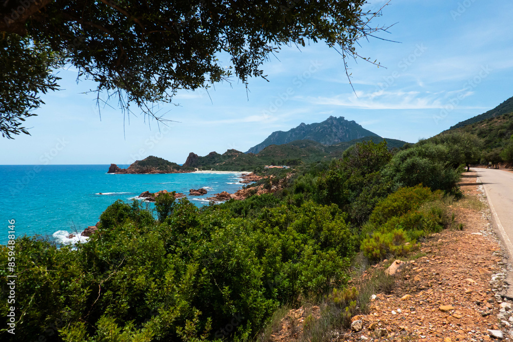 Obraz premium Picturesque road above wild Su Sirboni beach and red rock formations in province of Nuoro on Sardinia (Sardegna) island in Italy. Tyrrhenian Sea.