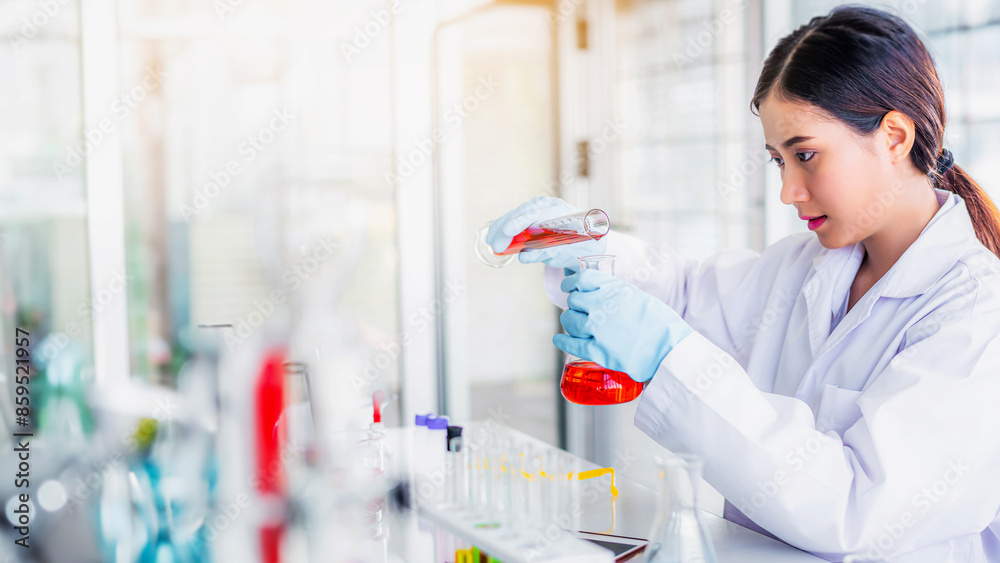Attractive young Asian scientist woman lab technician assistant analyzing sample in test tube at laboratory. Medical, pharmaceutical and scientific research and development concept	